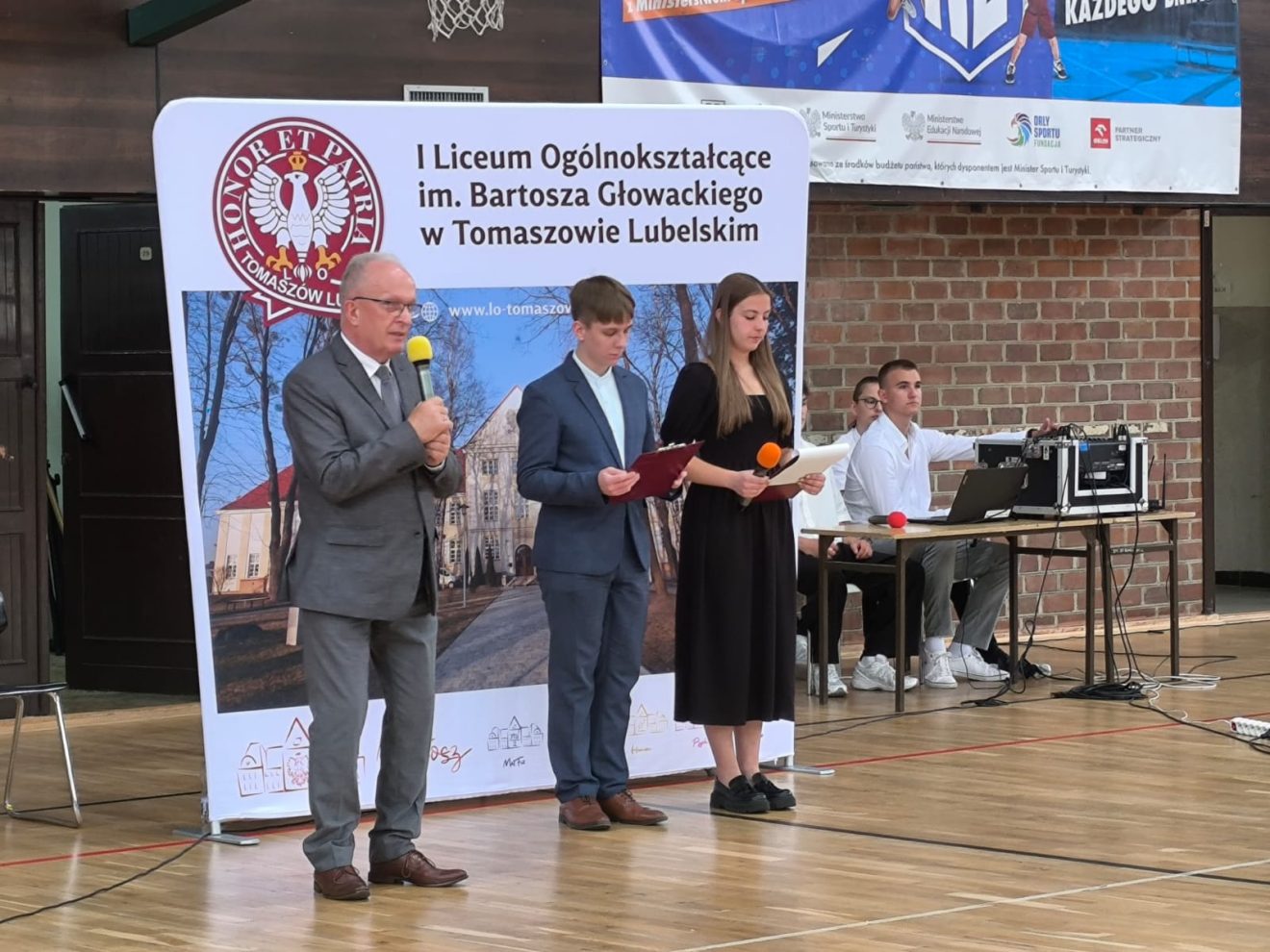 uczestnicy powiatowego zakończenia roku szkolnego 2024/2025 w I LO im. Bartosza Głowackiego w Tomaszowie Lubelskim, wśród nich przedstawiciele władz samorządowych i oświatowych powiatu tomaszowskiego.