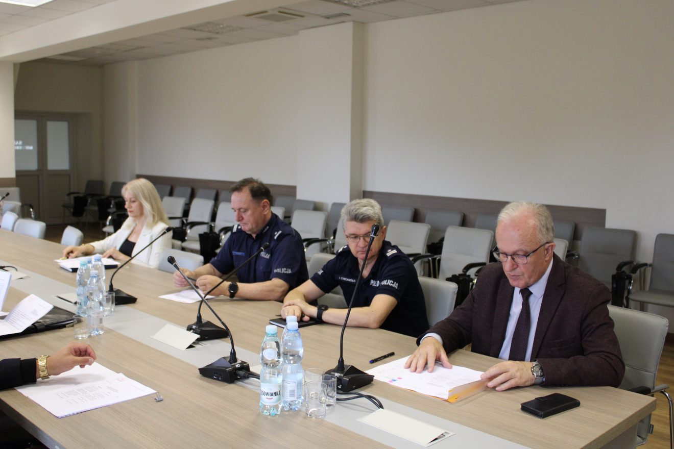 Uczestnicy posiedzenia Komisji Bezpieczeństwa i Porządku siedzą przy dużym stole konferencyjnym w sali Starostwa Powiatowego. Wśród obecnych są przedstawiciele służb mundurowych, instytucji publicznych oraz władz lokalnych. Na czele stołu znajduje się Starosta Tomaszowski Henryk Karwan, prowadzący obrady.
