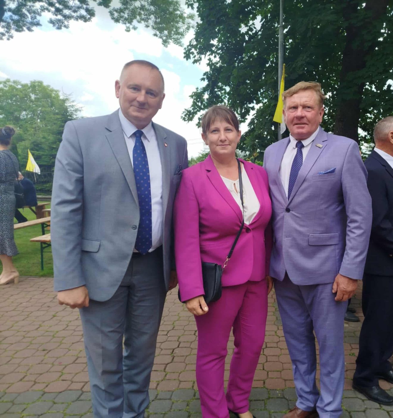 Uczestnicy wydarzenia stoją przed kościołem, pozując do zdjęcia.