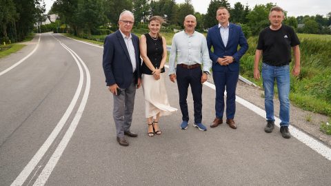 Zdjęcie przedstawia grupę osób stojących na zmodernizowanej drodze powiatowej. Na zdjęciu jest m.im Starosta Tomaszowski - Henryk Karwan , Jarosław Korzeń - Wicestarosta oraz Witold Pitura - Przewodniczący Rady Powiatu.