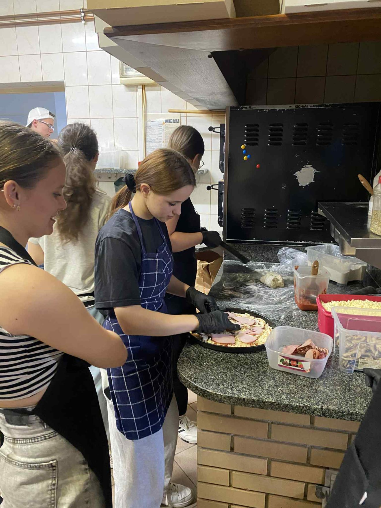 Uczniowie uczestniczą w zajęciach zawodoznawczych w branży gastronomicznej, poznając praktyczne aspekty pracy w zawodzie