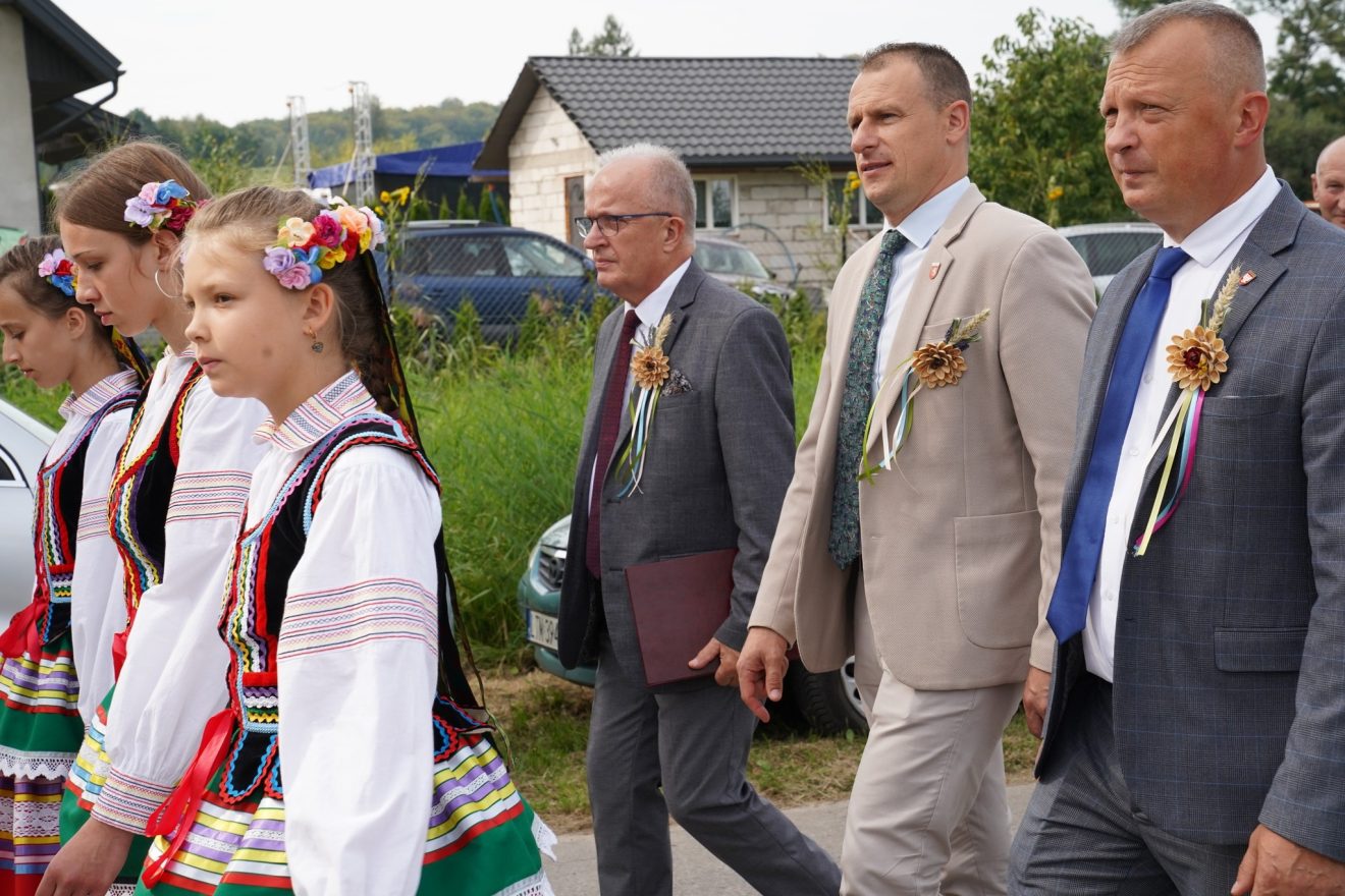 Uczestnicy Dożynek w Pawłówce, w tym Starosta Henryk Karwan i Przewodniczący Rady Powiatu Tomaszowskiego Witold Pitura, idą w barwnym korowodzie.