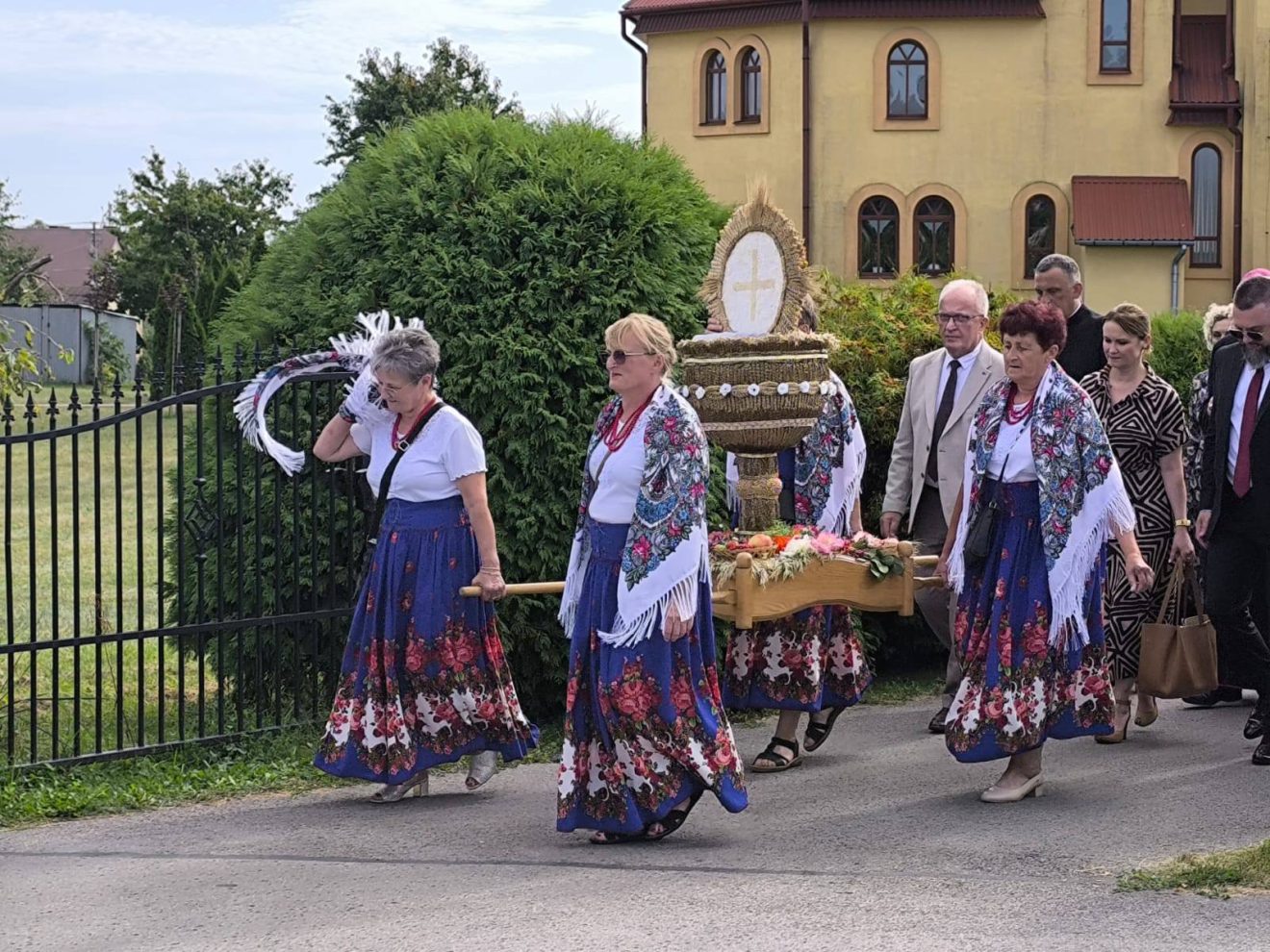 Starosta Tomaszowski idzie w korowodzie dożynkowym obok pań niosących wieniec dożynkowy