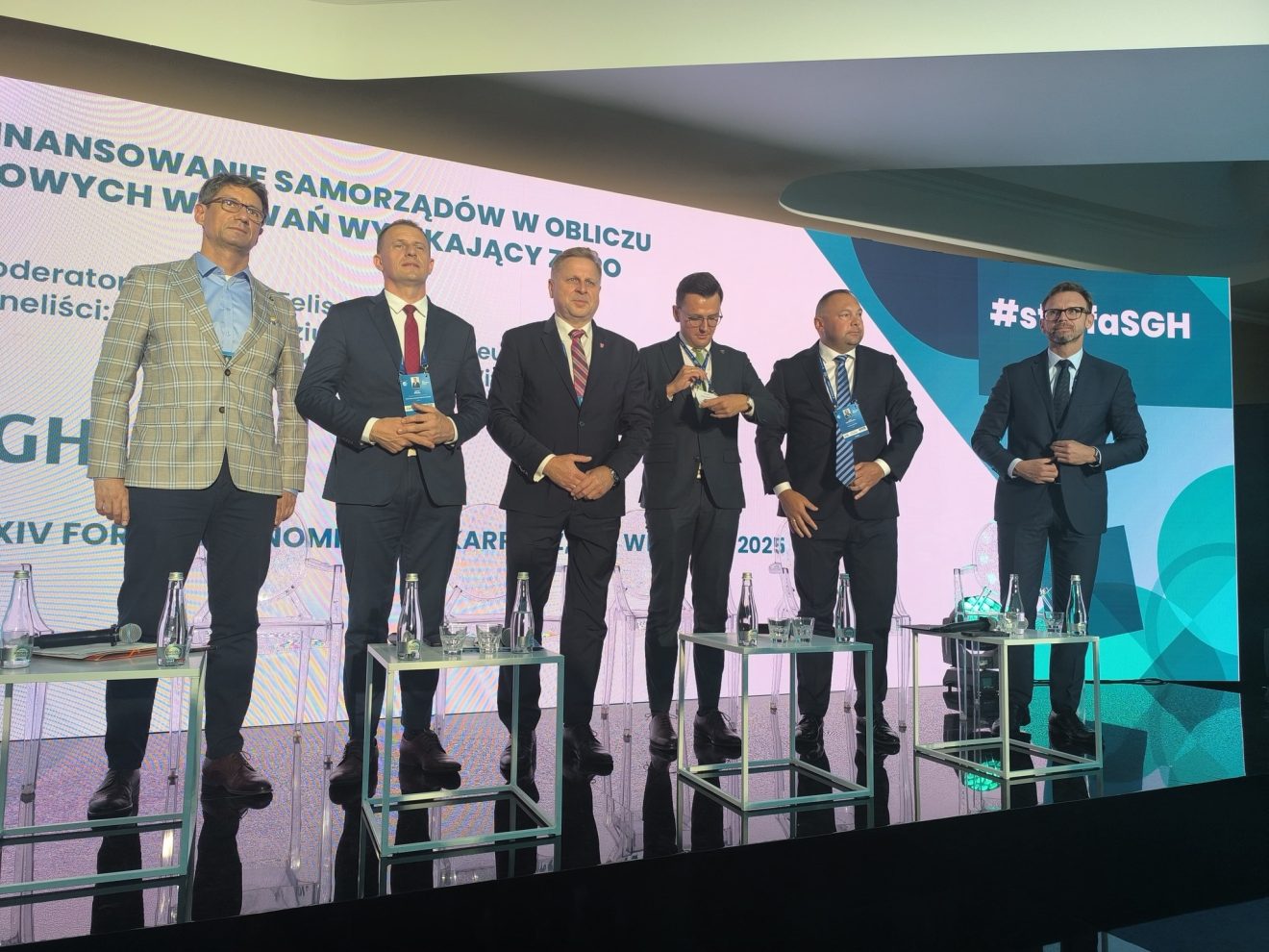 Uczestnicy panelu po zakończonej dyskusji pozują do wspólnego zdjęcia przed ścianką promocyjną XXXIV Forum Ekonomicznego w Karpaczu