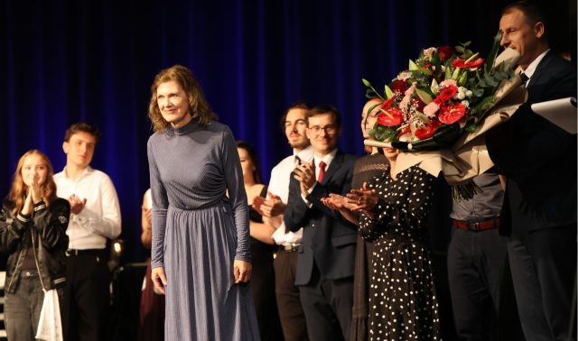 Na scenie stoją członkowie Tomaszowskiego Zespołu Teatralnego, obok nich przewodniczący Rady Powiatu Tomaszowskiego Witold Pitura trzymający bukiet kwiatów