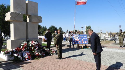 Wiesław Cielica pochyla głowę w zadumie przed pomnikiem na cmentarzu w Łaszczowie, oddając hołd poległym żołnierzom