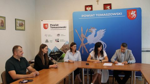 Członkowie komisji odbioru podczas podpisywania protokołu w siedzibie Starostwa Powiatowego w Tomaszowie Lubelskim, w tle ścianka promocyjna powiatu