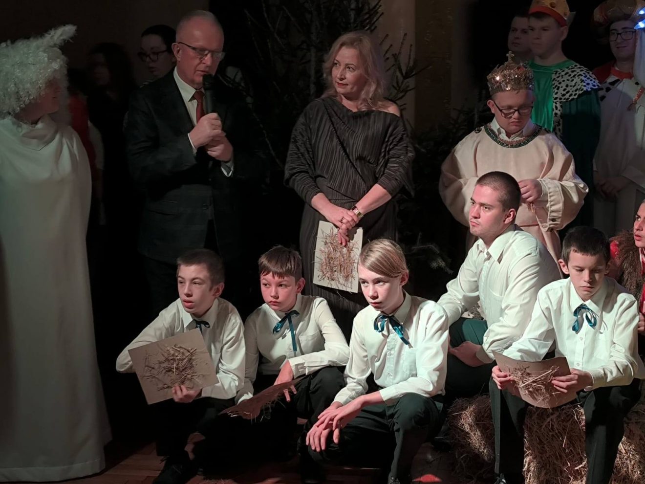 Starosta Tomaszowski przemawia podczas Wieczoru Wigilijnego, obok dyrektor szkoły oraz wychowankowie