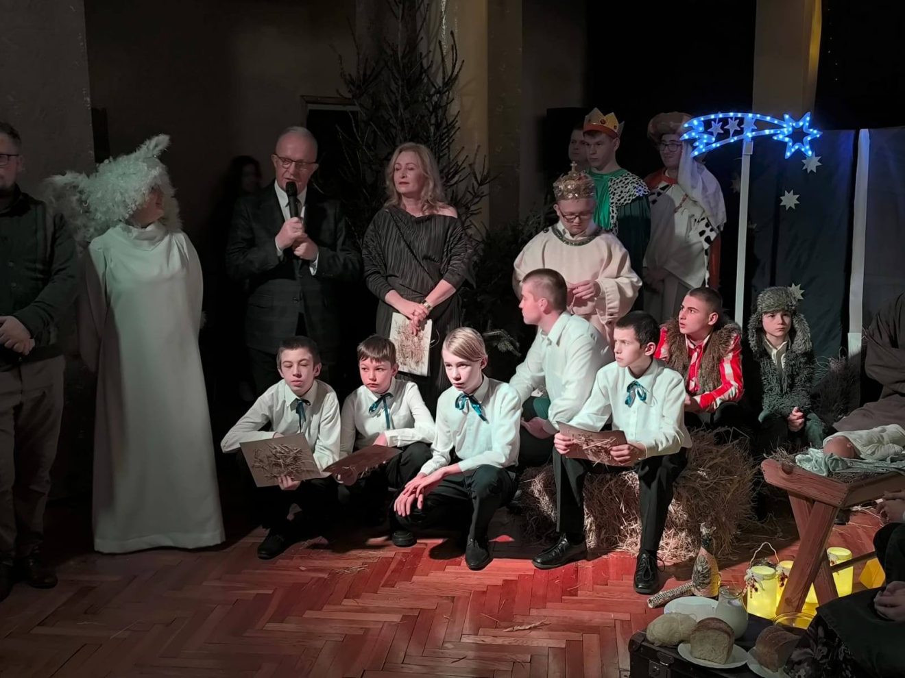 Starosta Tomaszowski przemawia podczas Wieczoru Wigilijnego, obok dyrektor szkoły oraz wychowankowie