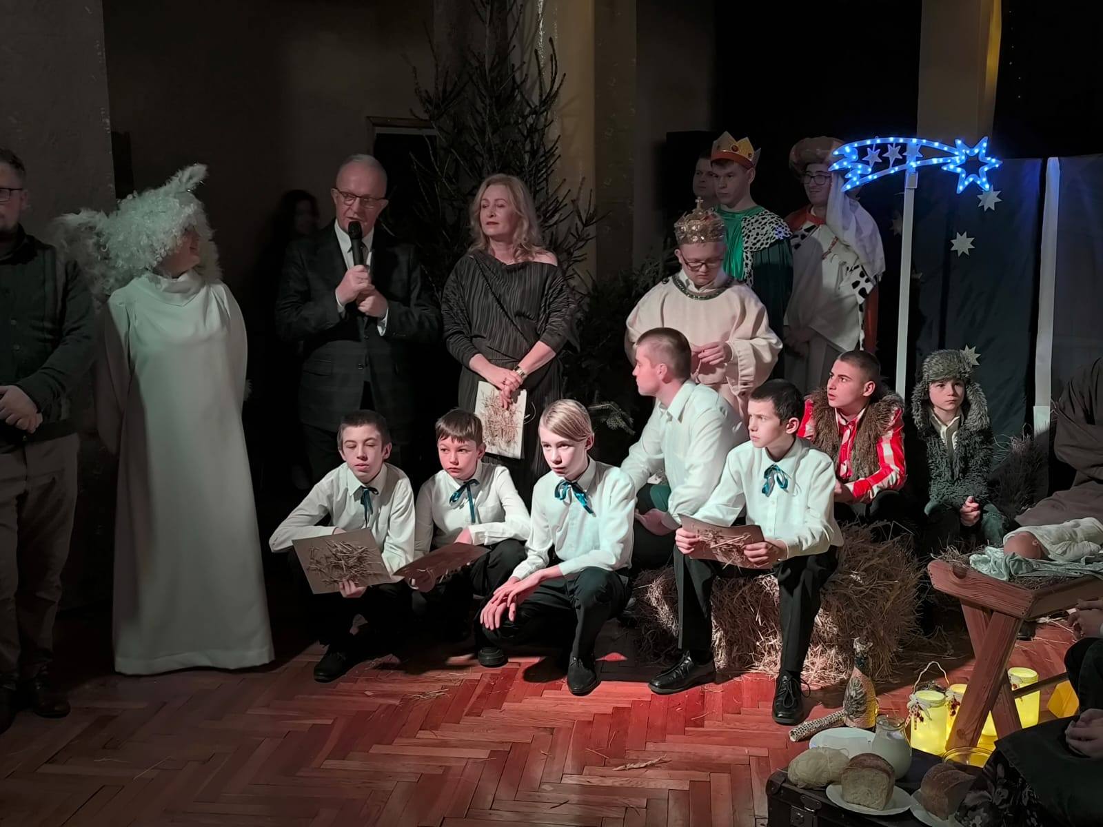 Starosta Tomaszowski przemawia podczas Wieczoru Wigilijnego, obok dyrektor szkoły oraz wychowankowie