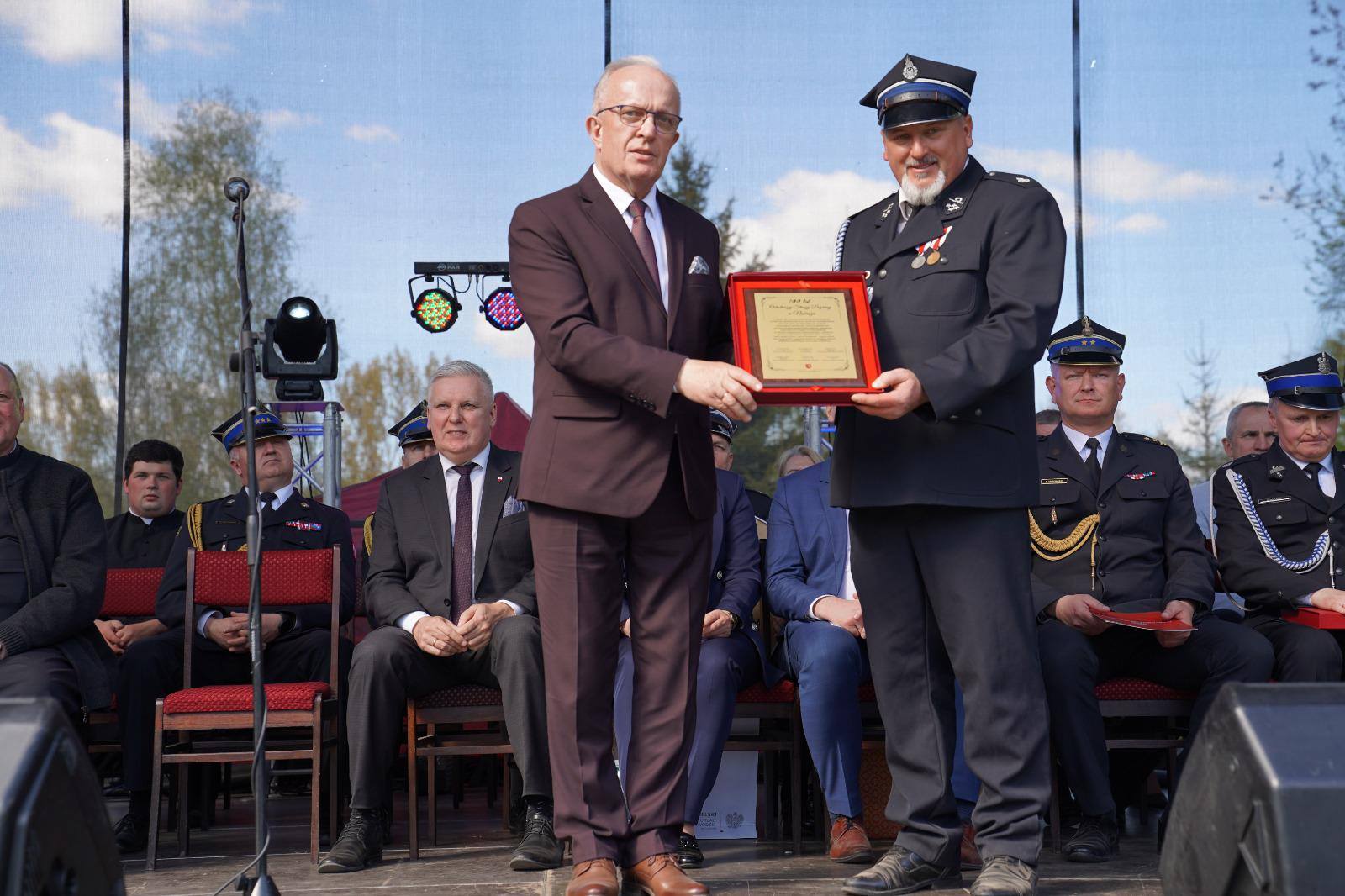 Na zdjęciu znajduje się Starosta Tomaszowski wręczający grawerton Komendantowi OSP W Nabrożu z okazji 100-lecia powstania Ochotniczej Straży Pożarnej w Nabrożu
