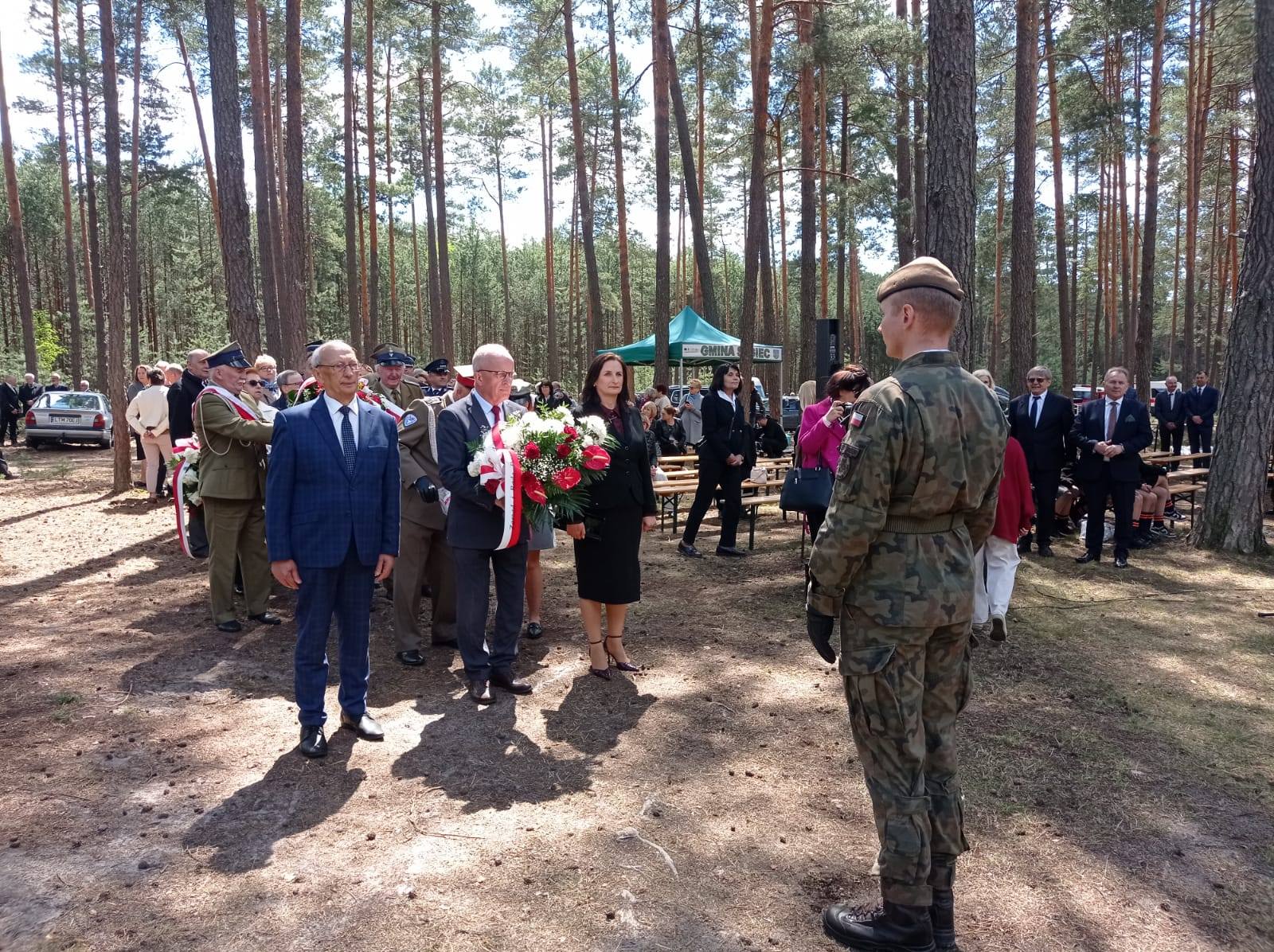 Na zdjęciu znajduje się Starosta Tomaszowski - Henryk Karwan, Radna Powiatu - Anna Kijko oraz Radny Tadeusz Suski, którzy składają wieniec przy pomniku upamietniającym poległych żołnierzy AK.