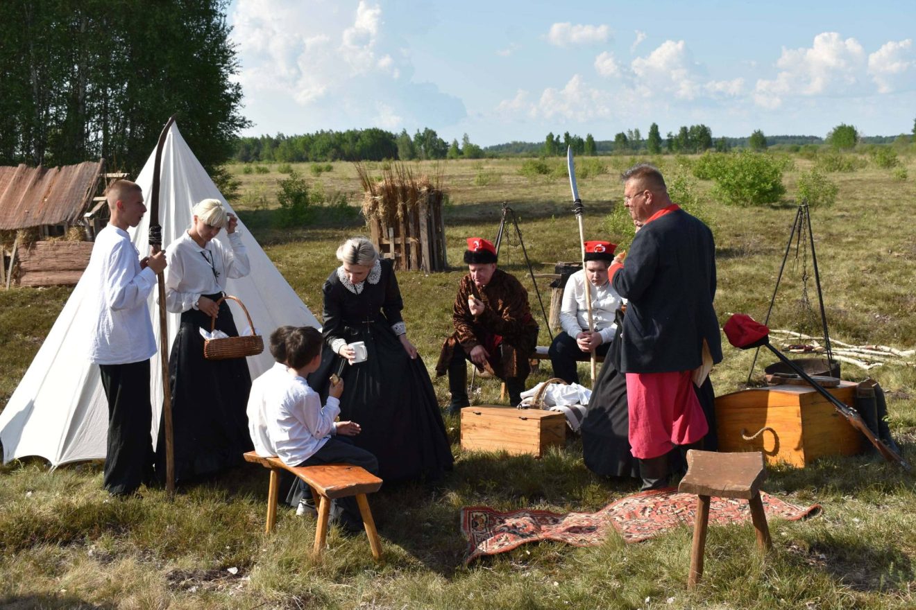 Rekonstruktorzy w strojach z epoki prezentują obozowisko powstańcze podczas inscenizacji historycznej.