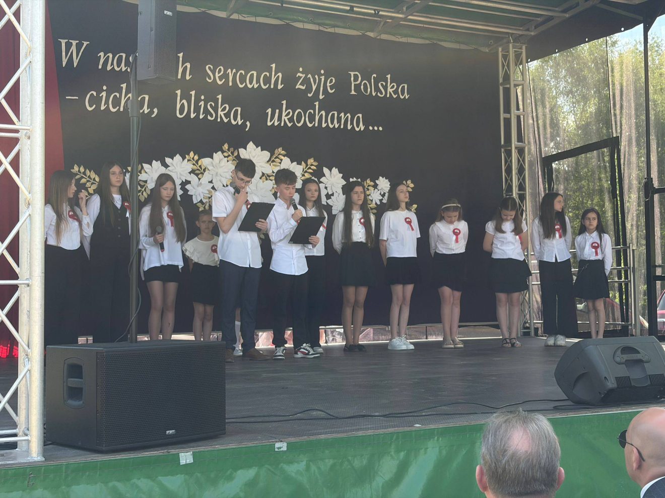 Dzieci i młodzież prezentują część artystyczną podczas uroczystości patriotycznych.