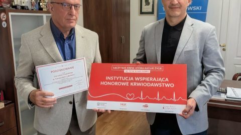 Na zdjęciu znajduje się Starosta Tomaszowski, który trzyma podziękowania za przeprowadzane akcje krwiodawstwa w Starostwie oraz przedstawiciel Regionalnego Centrum Krwiodawstwa i Krwiolecznictwa który trzyma w rękach tablicę z informacją o tom ,że Starostwo Powiatowe w Tomaszowie Lubelskim jest Instytucją wspierającą krwiodawstwo.