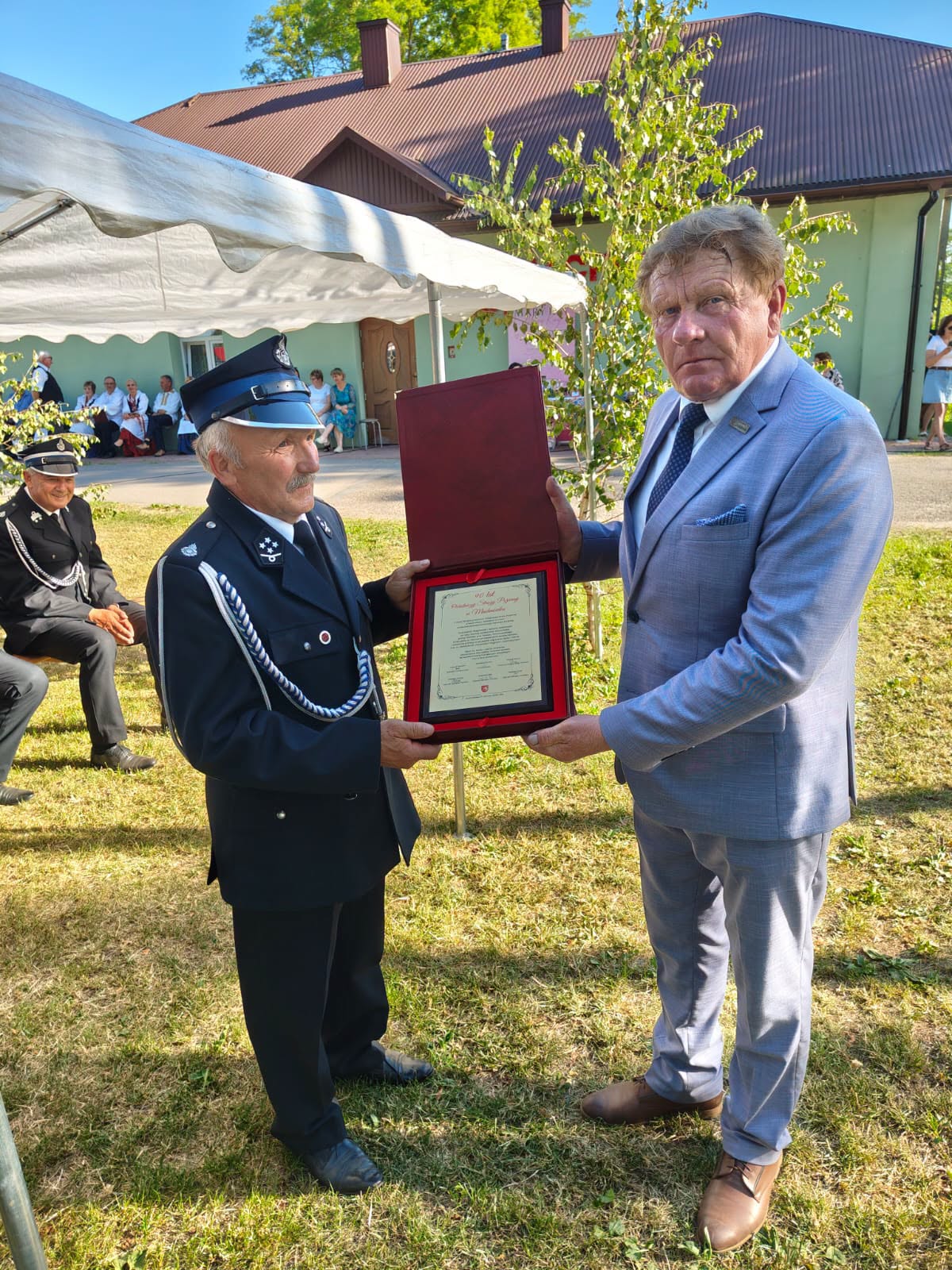 Na zdjęciu znajduje Wiesław Cielica - Członek Zarządu, wręczający pamiątkowy grawerton na ręce komendanta OSP w Machnówku.
