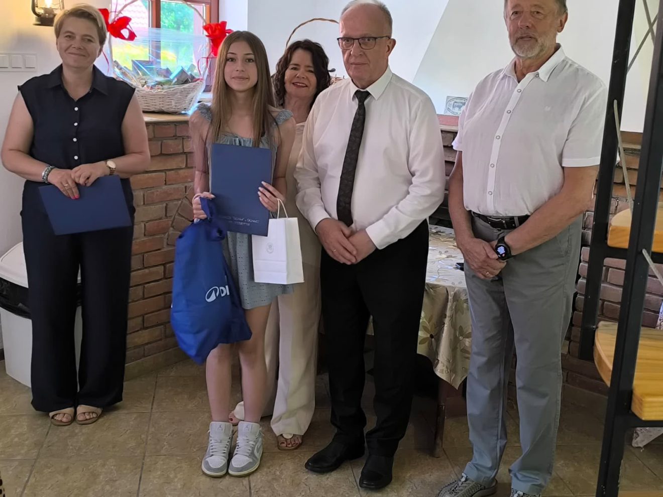 Na zdjęciu znajdują się Starosta Tomaszowski - Henryk Karwan oraz uczennica ze szkoły w Rachaniach oraz 3 inne osoby.