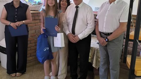 Na zdjęciu znajdują się Starosta Tomaszowski - Henryk Karwan oraz uczennica ze szkoły w Rachaniach oraz 3 inne osoby.