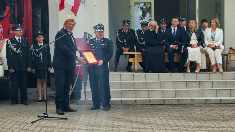 Przedstawiciel Powiatu Tomaszowskiego wręcza pamiątkowy grawerton podczas obchodów 75-lecia OSP Nowosiółki.