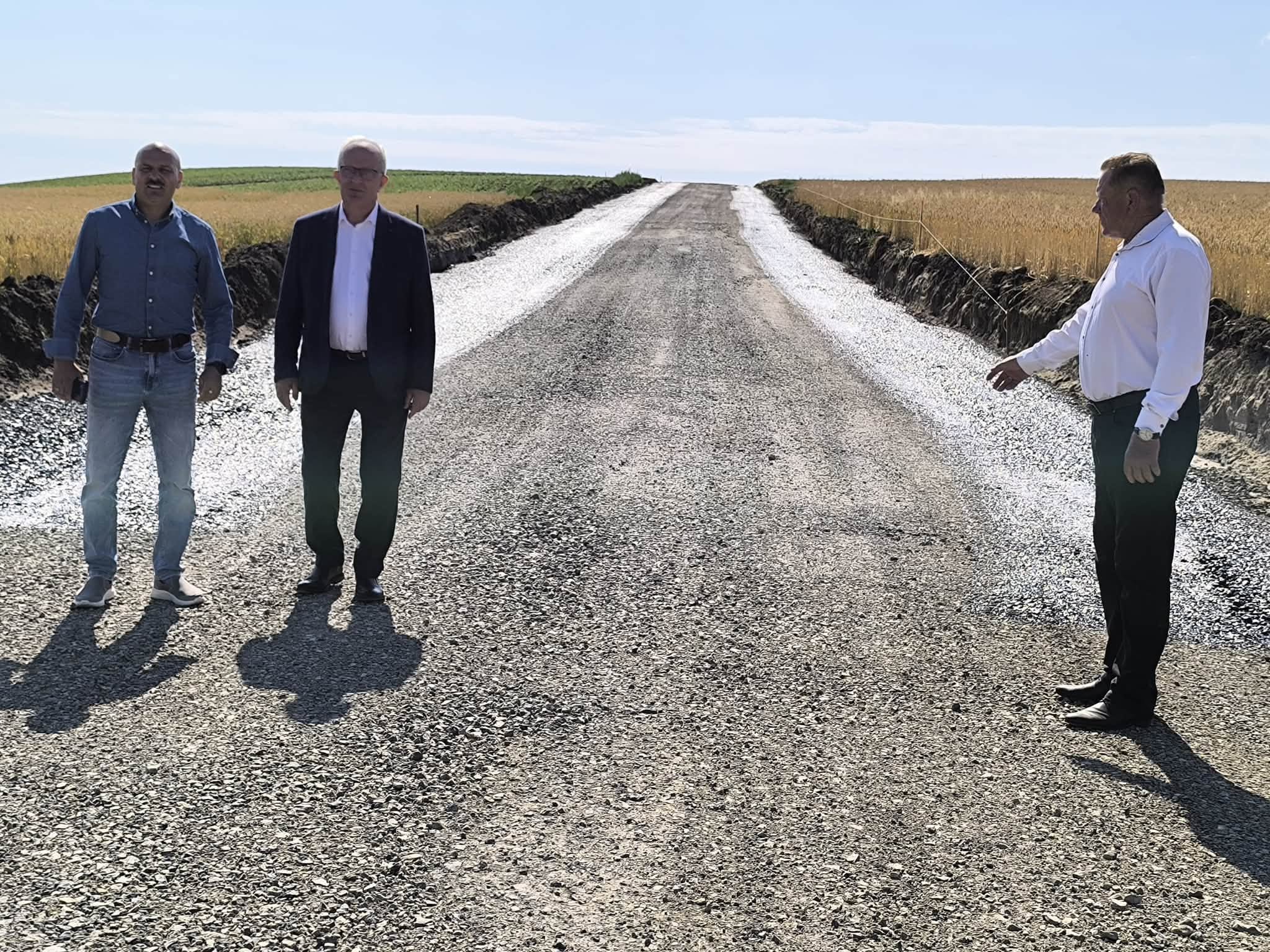 Na zdjęciu znajdują się Starosta Tomaszowski - Henryk Karwan, Wicestarosta- Jarosław Korzeń i Wiesław Cielica - Członek Zarządu, na tle nowo remontowanej drogi.