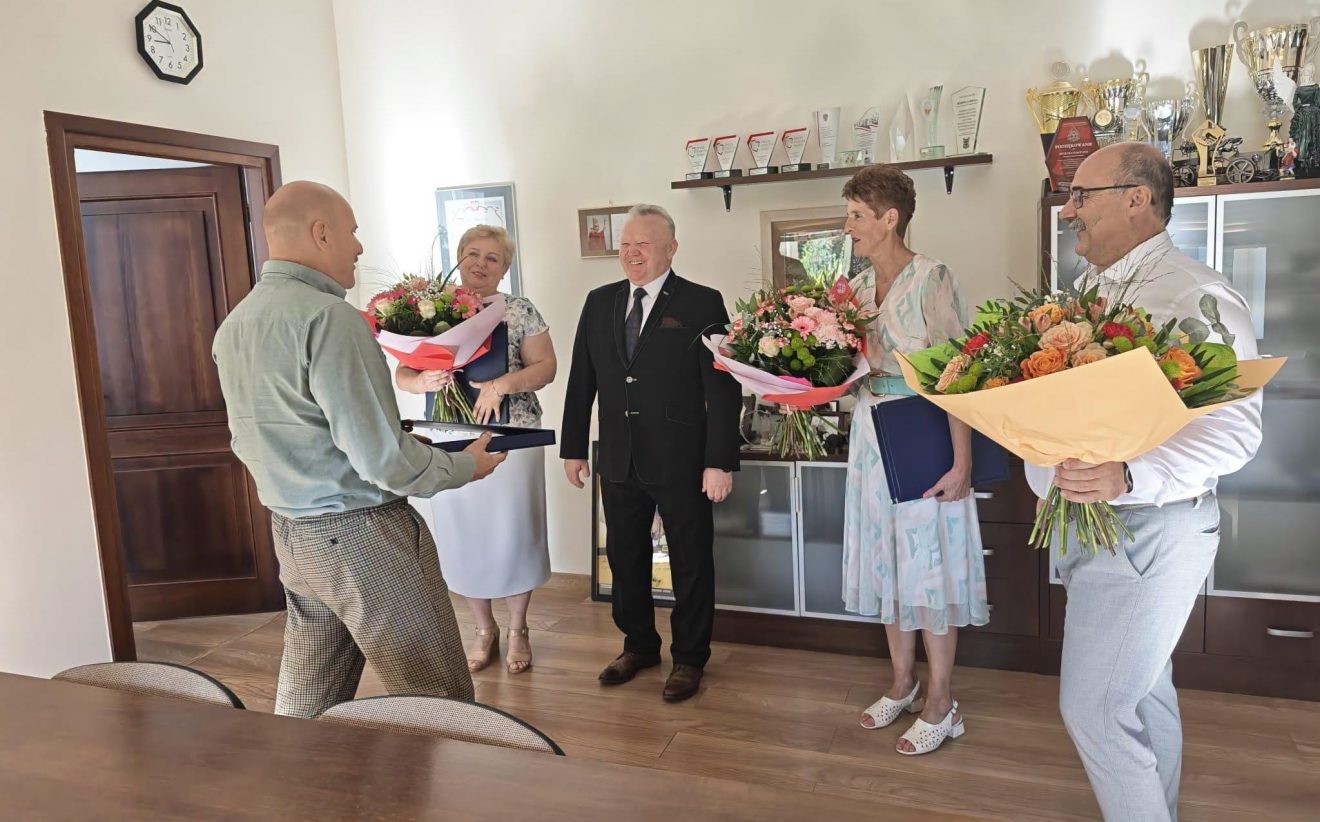Wicestarosta wręcza podziękowania i kwiaty pracownikom przechodzącym na emeryturę.