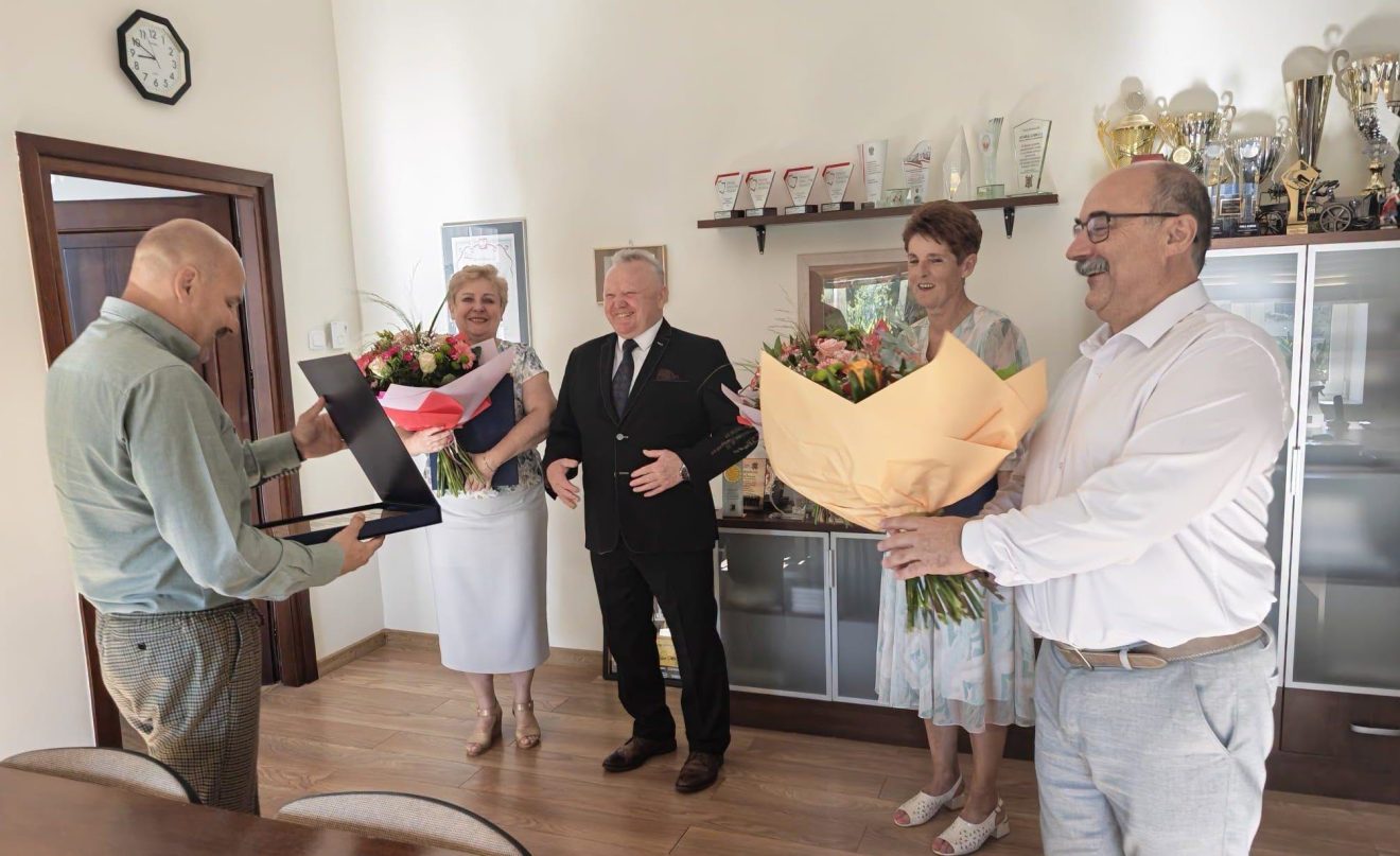 Pracownicy odbierają podziękowania i kwiaty z okazji zakończenia wieloletniej pracy zawodowej.