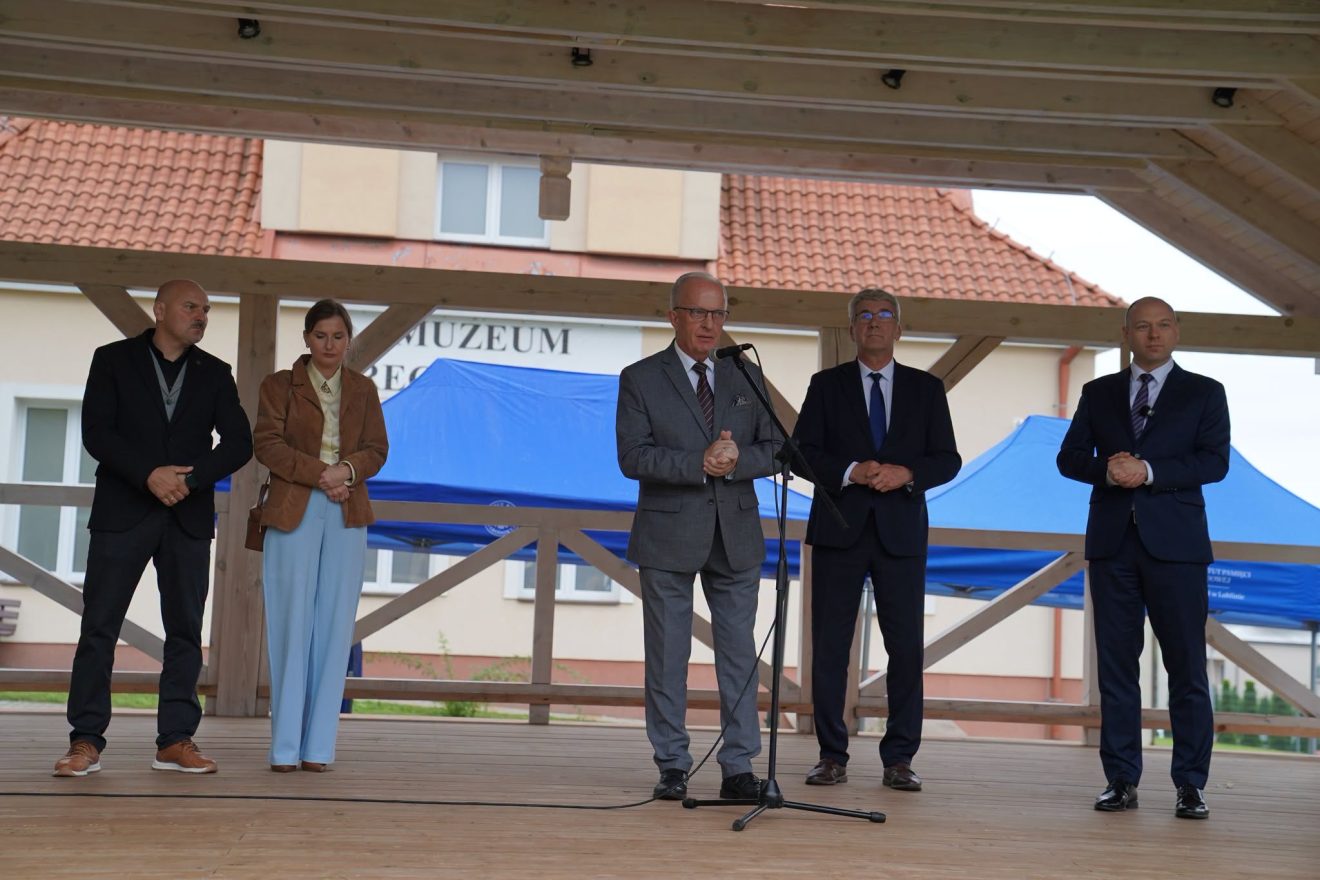 Starosta Tomaszowski Henryk Karwan podczas przemówienia na scenie wydarzenia „Wojenne Drogi”. Wraz z nim na scenie stoją przedstawiciele organizatorów i zaproszeni goście.