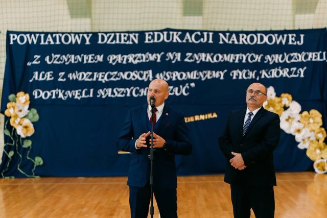 Wicestarosta Jarosław Korzeń przemawia do zgromadzonych podczas Powiatowego Dnia Edukacji Narodowej. Obok niego stoi Dariusz Czop, członek Zarządu Powiatu Tomaszowskiego.