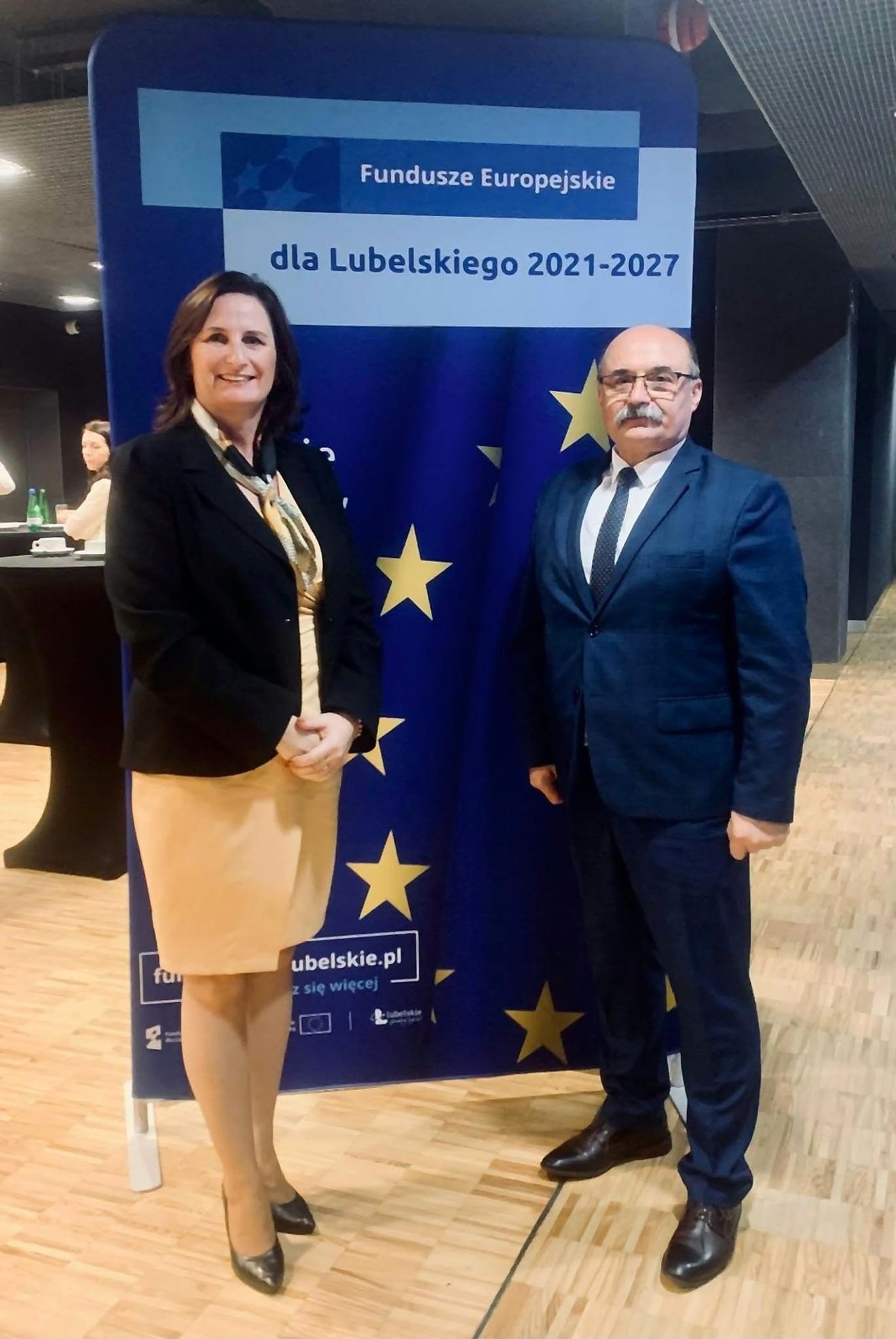 Zdjęcie 1: Przedstawiciele Powiatu Tomaszowskiego pozują na tle tablicy promującej Fundusze Europejskie dla Lubelskiego na lata 2021–2027.
